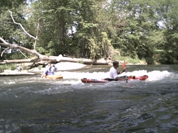 Monte plays at dam above Sleepy Hollow; portage is on concrete apron next to tree trunk in background